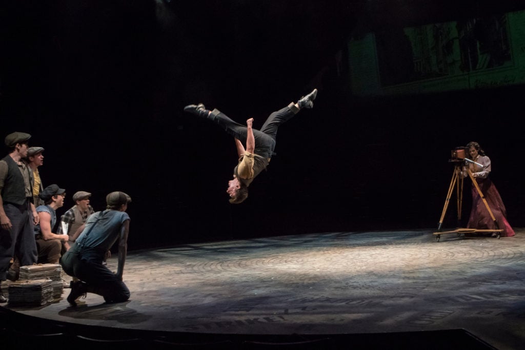 (center) Joshua Michael Burrage as Specs in DISNEY’S NEWSIES, produced by Broadway At Music Circus a