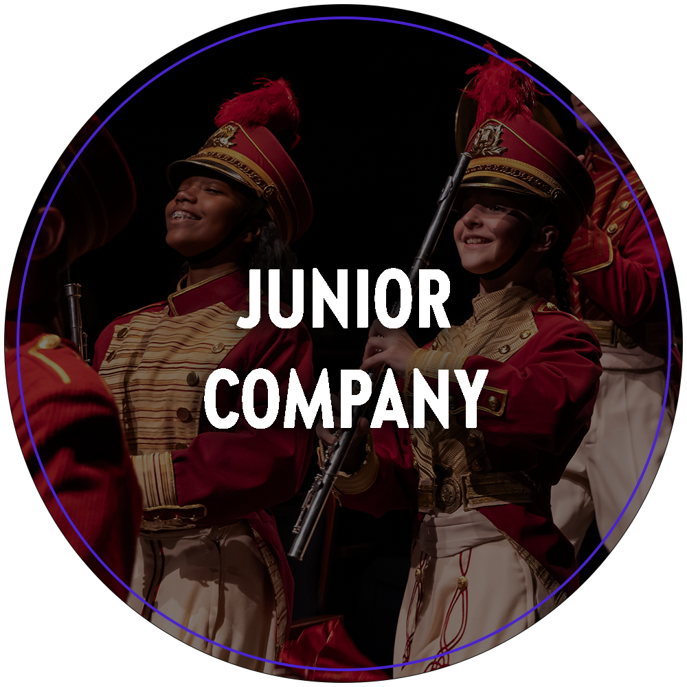 A circular image of a group young performers in marching band uniforms from the Broadway At Music Circus 2023 production of The Music Man. Text in the center of the image reads "Junior Company". 

You can click the image to redirect to the Junior Company web page. 